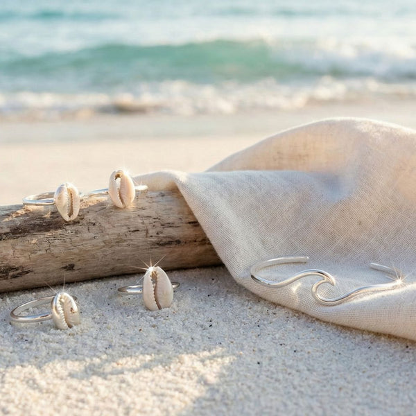 several real Sterling silver rings on white sand beach