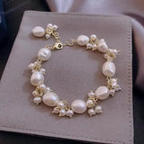 Baroque pearl bracelet with gold accents displayed on grey suede, beach vibes aesthetic.