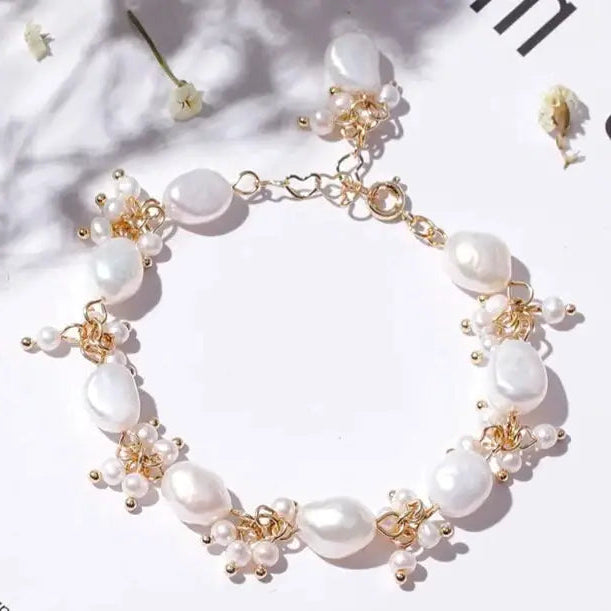Iridescent baroque pearl bracelet on satin surface, feminine seaside elegance.