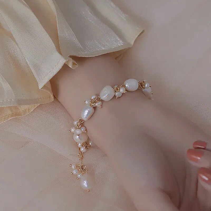Close-up of irregular pearl bracelet on skin, showcasing ocean-inspired jewelry.
