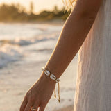Woman wearing a bracelet on a beach with a blurred background