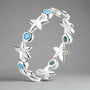 A sterling silver ring featuring a series of starfish shapes with blue zircon stones set in them, displayed against a neutral background.
