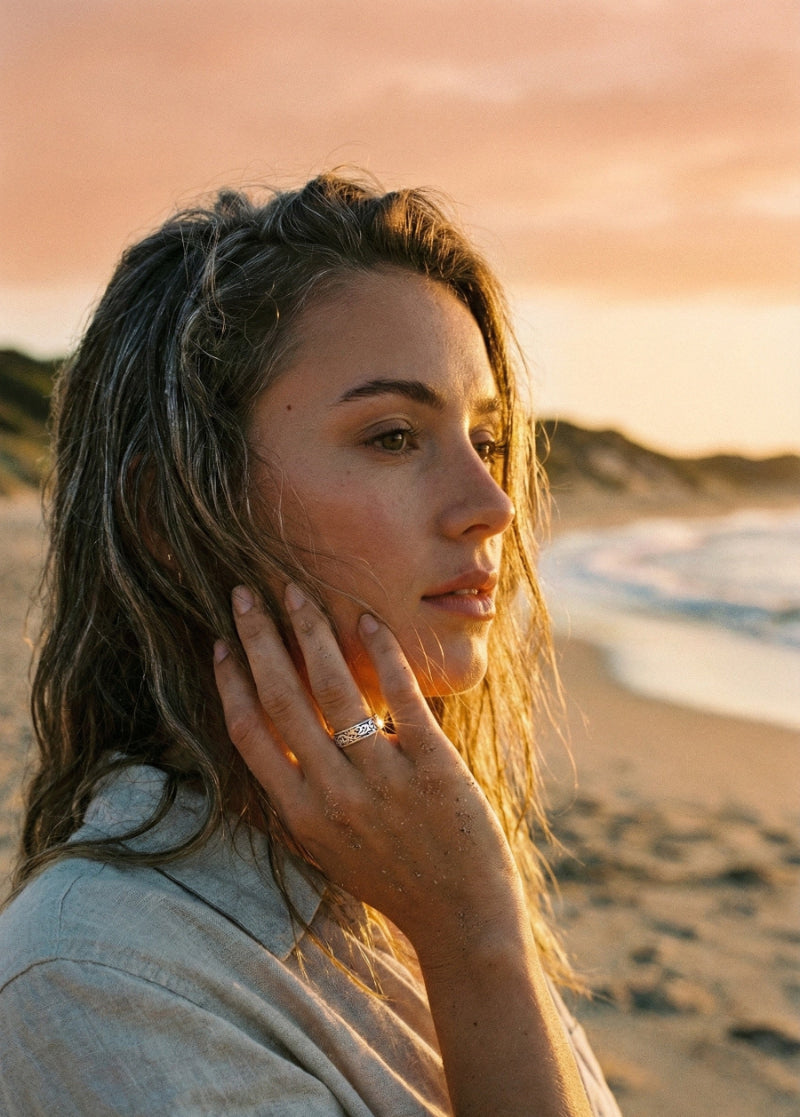 Woman on a beach at sunset with a ring on her finger