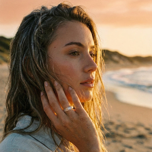 Woman on a beach at sunset with a ring on her finger