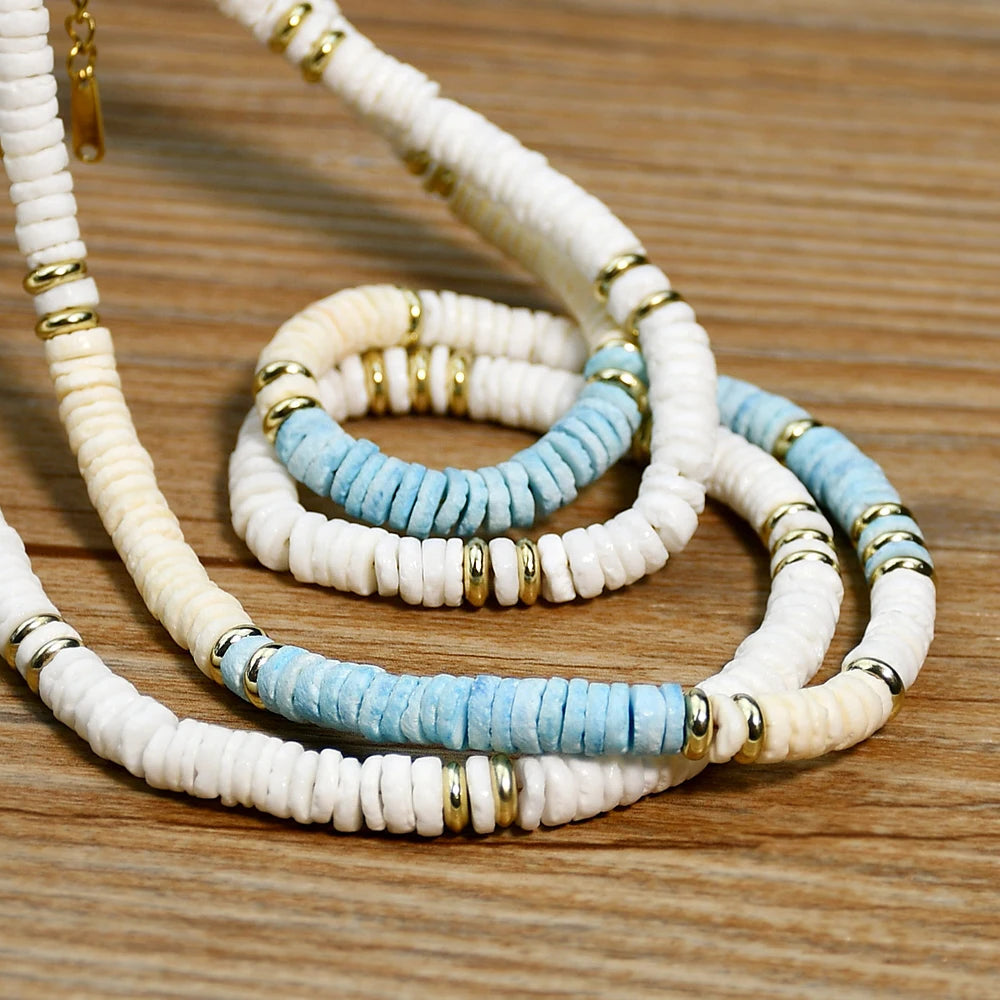 Close-up of blue and beige shell beads with gold spacers showcasing handcrafted details