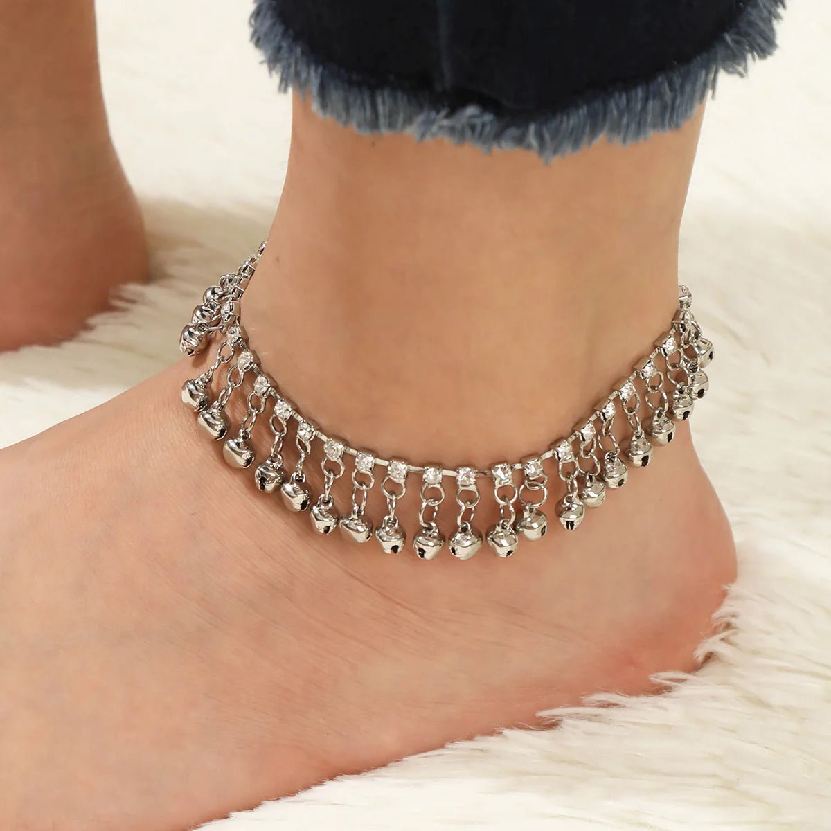 Adjustable silver bell anklet worn on ankle, showcasing soft movement and boho elegance.