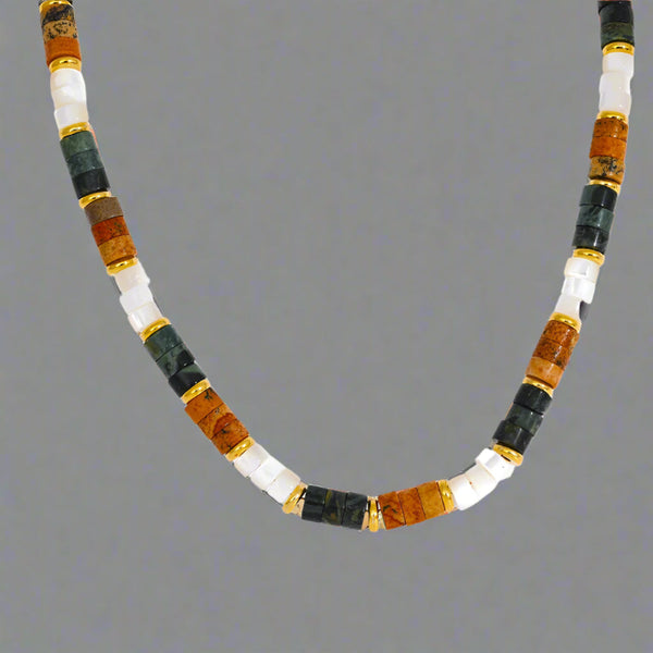 Detailed product shot of multicolor shell and jasper bead necklace with gold accents.
