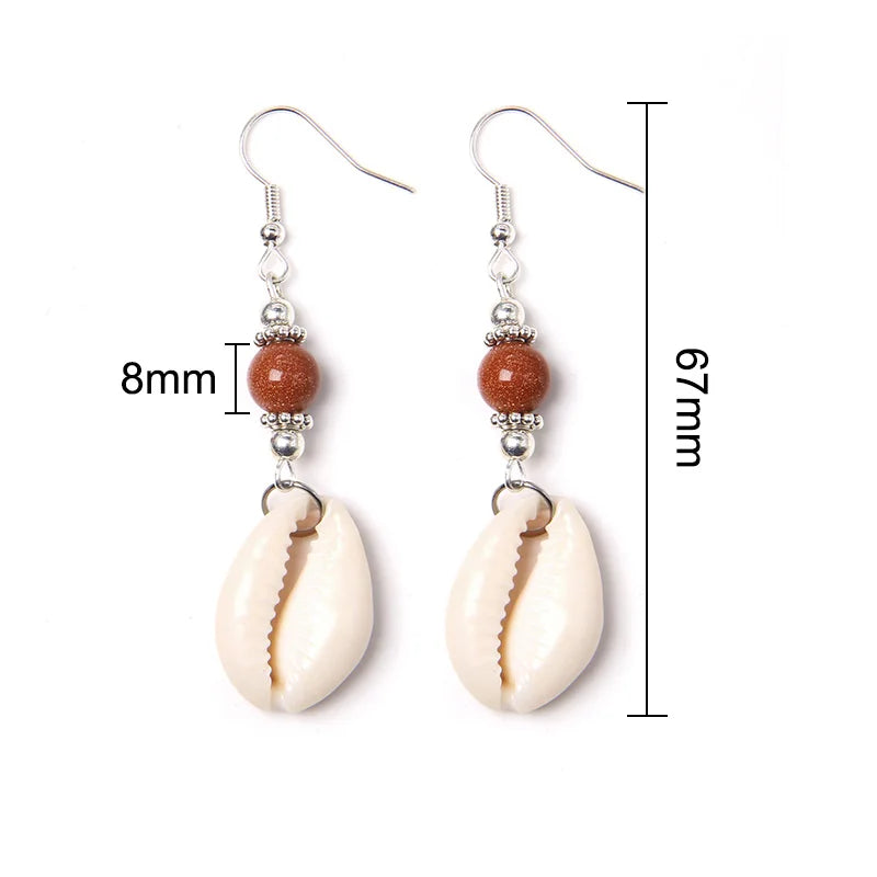 Cowrie shell earrings with measurement details on a white background