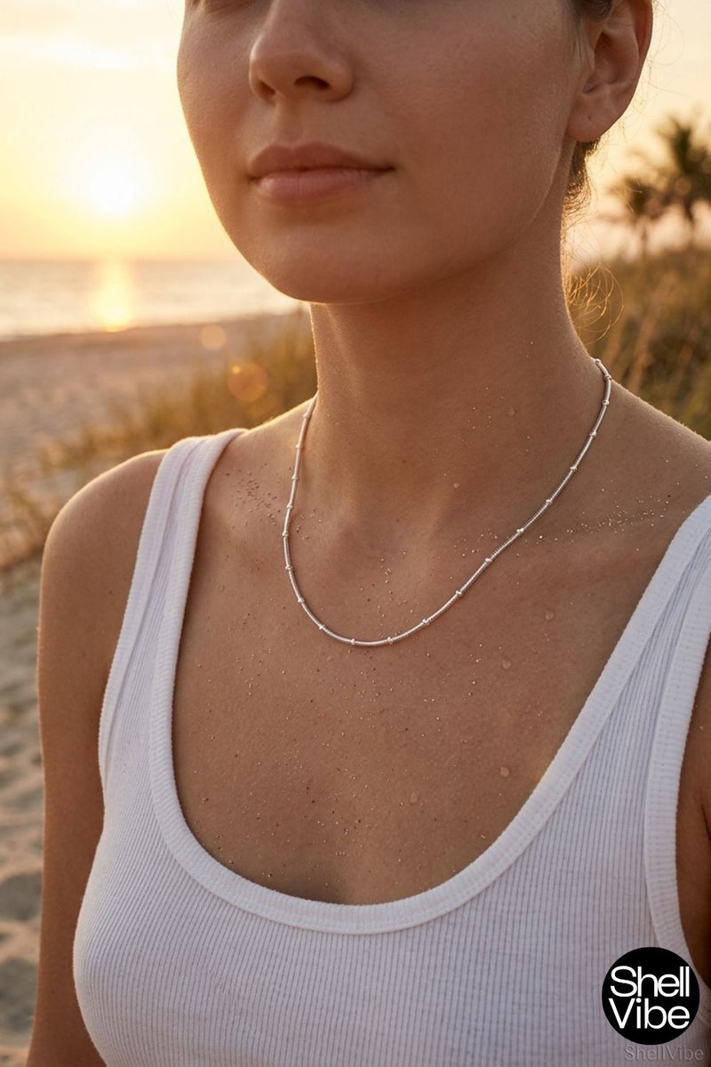 Woman wearing a sterling silver necklace on a beach at sunset