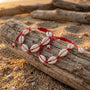 Cowrie shell bracelet on a piece of driftwood with a beach background