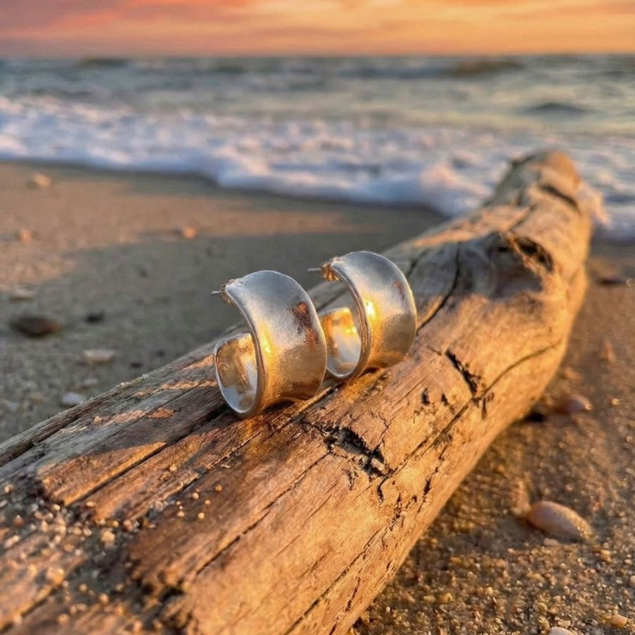 silver sterling hoops on drift wood on the beach