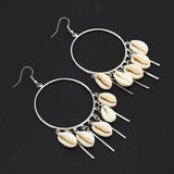 Cowrie Hoop earrings with shell charms on a black background