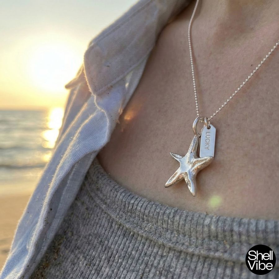Sterling silver starfish pendant necklace on a person with a beach sunset background