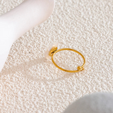 Gold ring with flower mother of pearl design on a textured white surface