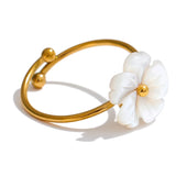 Gold ring with a white flower-shaped nacre  on a white background