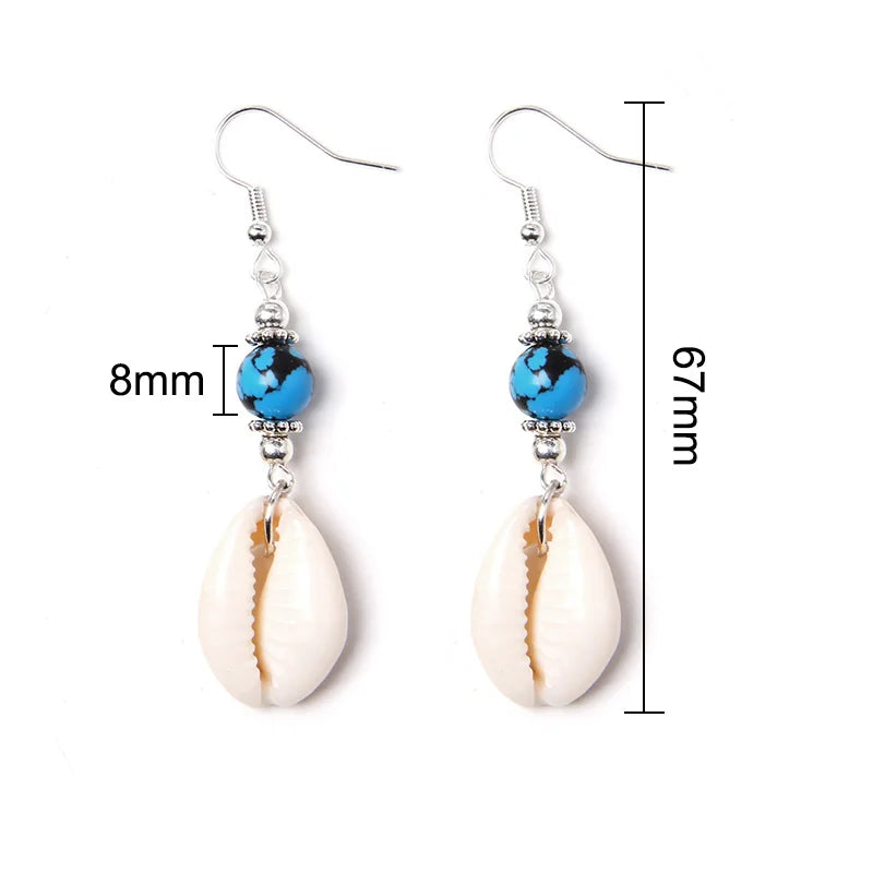 Cowrie shell earrings with blue beads and measurements on a white background