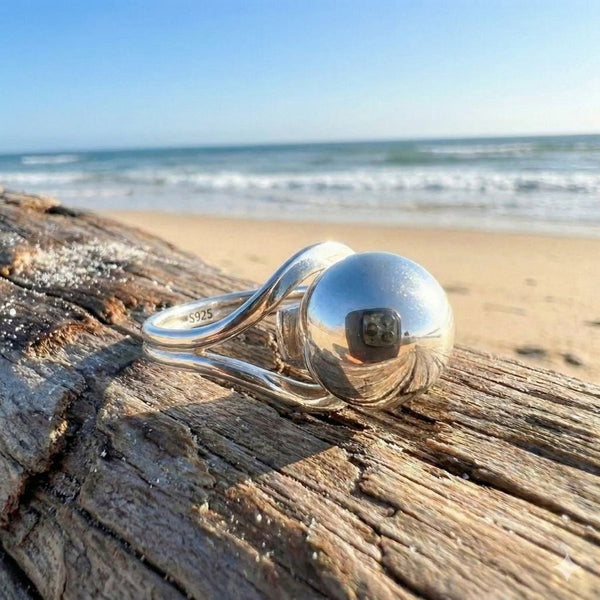 sterling silver pearl ring on drif wood, ocean background