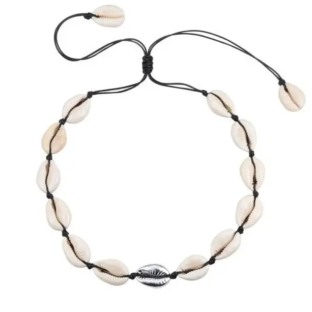 Cowrie shell necklace on a piece of driftwood with white background