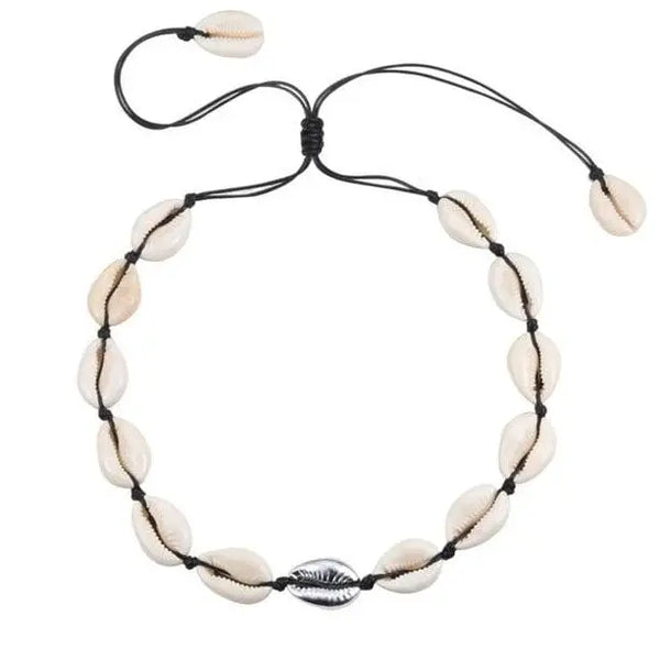 Cowrie shell necklace on a piece of driftwood with white background