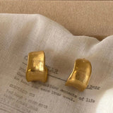 golden sterling silver hoops on white denim