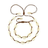 A Cowrie Necklace and Bracelet Set with white and brown cowrie shells linked together on a fine cord with a sliding clasp.