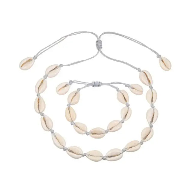 A Cowrie Necklace and Bracelet Set with white and brown cowrie shells linked together on a fine cord with a sliding clasp.