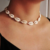 white cowrie necklace on a woman neck