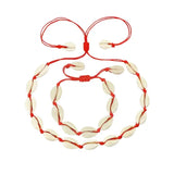 A Cowrie Necklace and Bracelet Set with white and brown cowrie shells linked together on a fine cord with a sliding clasp.