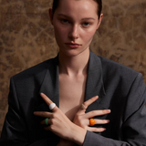 “Model wearing multiple colorful enamel dome rings on both hands, styled with a dark blazer.”
