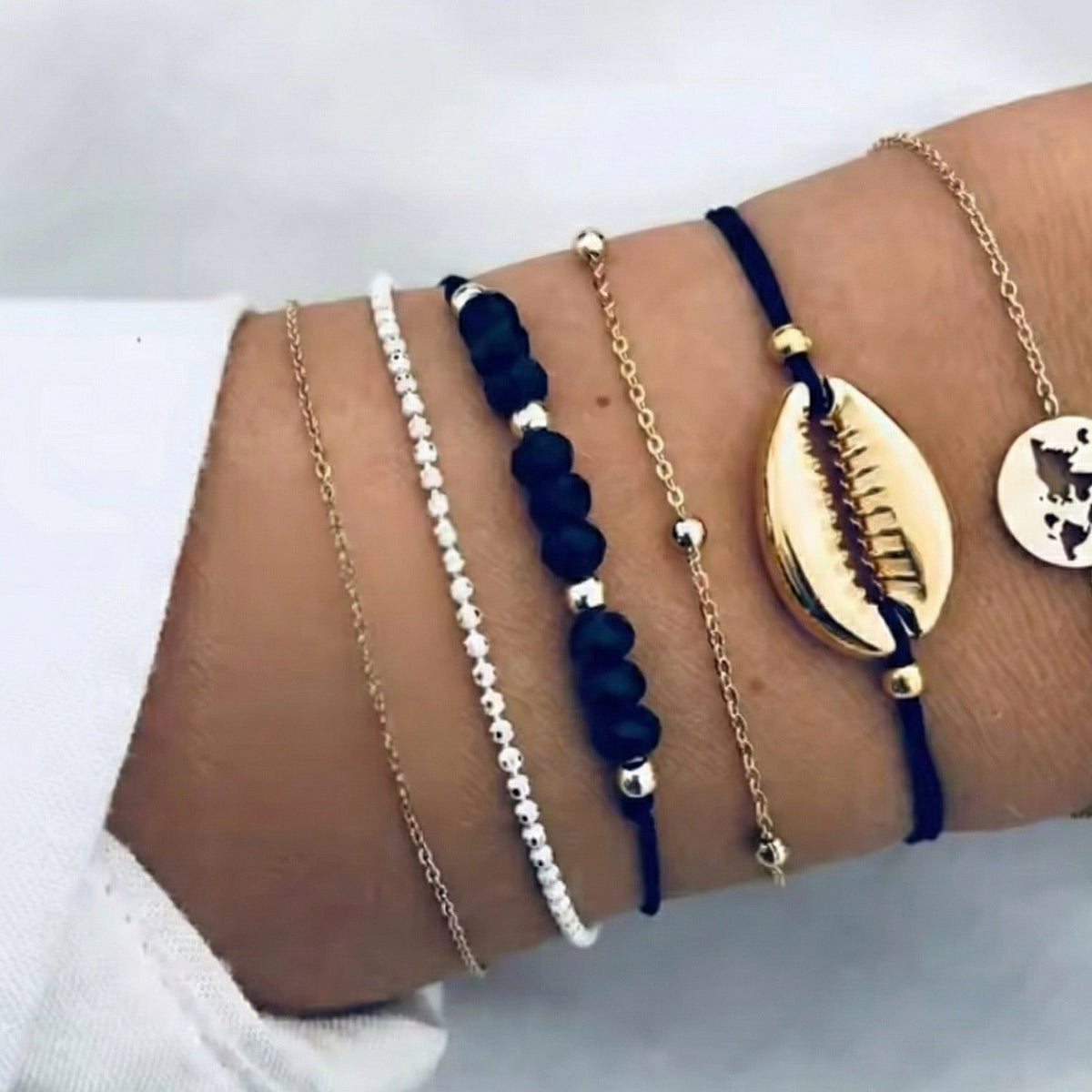 Multiple bracelets on a wrist against a white background