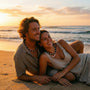 Couple sitting on a beach at sunset with beaded surfer necklace