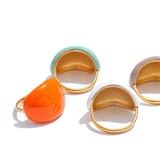 Set of three gold-rimmed rings with colorful stones on a white background